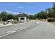 Community entrance showing gatehouse with security stop and well maintained entryway landscaping at 504 Hawthorne Blvd, Leesburg, FL 34748