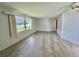 Open living area with large window, neutral walls, and updated wood-look flooring for a modern touch at 504 Hawthorne Blvd, Leesburg, FL 34748