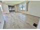 Spacious living area with wood-look flooring, bright windows, and access to Florida room for a seamless transition at 504 Hawthorne Blvd, Leesburg, FL 34748
