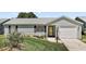 Charming home featuring a well-manicured lawn, lush landscaping, and a welcoming front entrance at 517 San Pedro Dr, Lady Lake, FL 32159