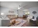Bright living room featuring hardwood floors, neutral-colored walls, ceiling fan, and comfortable seating arrangement at 517 San Pedro Dr, Lady Lake, FL 32159