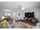 Open-concept living area with hardwood floors, ceiling fan, television, and seamless flow into the dining area at 517 San Pedro Dr, Lady Lake, FL 32159