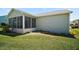 Charming sunroom with ample windows, perfect for relaxing and enjoying natural light, with a well maintained lawn at 517 San Pedro Dr, Lady Lake, FL 32159
