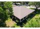 This aerial view displays the home's screened lanai and the surrounding mature trees at 5209 Grove Mnr, Lady Lake, FL 32159