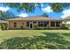 Expansive backyard with lush green lawn, landscaping, and a view of the home's rear at 5209 Grove Mnr, Lady Lake, FL 32159