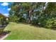 Spacious backyard featuring lush green grass and mature trees at 5209 Grove Mnr, Lady Lake, FL 32159