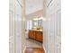 Hallway view of the bathroom featuring wood cabinetry, double sinks and ample lighting at 5209 Grove Mnr, Lady Lake, FL 32159