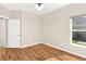 A cozy bedroom with vinyl floors, a ceiling fan, and a window with a view of the yard at 5209 Grove Mnr, Lady Lake, FL 32159