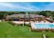 Aerial shot of community clubhouse, swimming pool, and immaculate green landscaping at 5209 Grove Mnr, Lady Lake, FL 32159