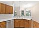Bright eat-in kitchen featuring wood cabinetry, stainless steel dishwasher, and ample counter space at 5209 Grove Mnr, Lady Lake, FL 32159