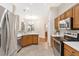 Well-lit kitchen with stainless steel appliances, wood cabinets, and modern pendant lighting at 5209 Grove Mnr, Lady Lake, FL 32159