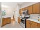 Modern kitchen showcasing stainless steel appliances, wood cabinets, and a stylish range hood at 5209 Grove Mnr, Lady Lake, FL 32159