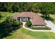 Aerial view of a single-Gathering home with a well-manicured lawn and mature trees at 5306 Greens Dr, Lady Lake, FL 32159