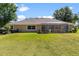 View of the backyard showcasing the lawn and screened patio at 5306 Greens Dr, Lady Lake, FL 32159