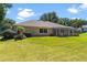 View of the backyard highlighting the landscaped lawn and screened patio at 5306 Greens Dr, Lady Lake, FL 32159