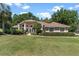 Charming home with a well-maintained lawn, mature trees, and a welcoming entryway at 5306 Greens Dr, Lady Lake, FL 32159