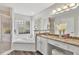 Luxurious main bathroom features a soaking tub, walk-in shower, and granite countertops at 5306 Greens Dr, Lady Lake, FL 32159