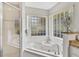 Close-up of modern soaking tub with walk-in shower and vanity in main bathroom at 5306 Greens Dr, Lady Lake, FL 32159