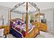 Bright main bedroom boasts a four-poster bed, a ceiling fan, and bright windows at 5306 Greens Dr, Lady Lake, FL 32159