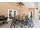 Covered patio featuring a ceiling fan, dining table and a grill at 5306 Greens Dr, Lady Lake, FL 32159