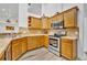 Bright kitchen features wood cabinets, stainless steel appliances, and tile countertops at 5433 County Road 125, Wildwood, FL 34785