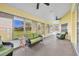 Relaxing sunroom with comfortable wicker seating and serene views of the lush backyard at 5433 County Road 125, Wildwood, FL 34785