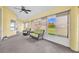 Bright sunroom with comfortable seating, large windows, and a ceiling fan for relaxing afternoons at 5433 County Road 125, Wildwood, FL 34785