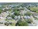 This aerial view displays the homes, their landscaping, and the community layout featuring trees and nearby bodies of water at 5614 King James Ave, Leesburg, FL 34748