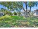 Expansive backyard showcases a well-manicured lawn, mature trees, and a screened-in lanai, ideal for outdoor enjoyment at 5614 King James Ave, Leesburg, FL 34748