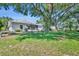 Beautiful backyard featuring a well-maintained lawn, shade trees, and a screened lanai perfect for relaxing and entertaining at 5614 King James Ave, Leesburg, FL 34748