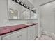 This bathroom boasts modern vanity with red countertop and stylish mirror and lighting at 5614 King James Ave, Leesburg, FL 34748