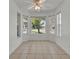 Cozy dining area with tile flooring, ceiling fan, and natural light pouring in from three large windows at 5614 King James Ave, Leesburg, FL 34748