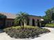 Beautiful building exterior with lush landscaping, including colorful flowers and mature palm trees at 5614 King James Ave, Leesburg, FL 34748