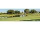 Expansive golf course view with serene pond and mature trees, creating a picturesque landscape at 5614 King James Ave, Leesburg, FL 34748