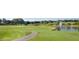 Scenic view of a golf course with a tranquil pond, fountain feature, and lush green landscape at 5614 King James Ave, Leesburg, FL 34748