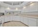 Well-lit kitchen featuring white cabinets, tile floors, and stainless steel appliances at 5614 King James Ave, Leesburg, FL 34748