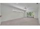 Bright open-concept living room with carpet floors, ceiling fan, and sliding glass doors at 5614 King James Ave, Leesburg, FL 34748