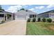 Well-maintained home featuring a manicured lawn, 2-car garage, and charming picket fence at 5817 Valente Ct, The Villages, FL 32163