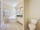 Bright bathroom featuring a glass enclosed shower, soaking tub, and single vanity with granite counters at 807 Wolf Creek St, Clermont, FL 34711