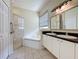 Bathroom featuring double vanity with granite counters, soaking tub and glass shower enclosure at 807 Wolf Creek St, Clermont, FL 34711