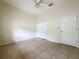 Bedroom features neutral walls, tile flooring, closet, ceiling fan and a white door at 807 Wolf Creek St, Clermont, FL 34711