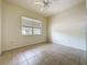 Bedroom with neutral walls, tile flooring, ceiling fan, and a window providing natural light at 807 Wolf Creek St, Clermont, FL 34711