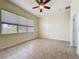 Well-lit bedroom with a ceiling fan, tile floors, and large windows at 807 Wolf Creek St, Clermont, FL 34711