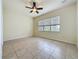 Bedroom features neutral walls, tile flooring, ceiling fan, and a window providing natural light at 807 Wolf Creek St, Clermont, FL 34711