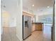Well-lit kitchen with stainless steel refrigerator and tile flooring flowing into the living area at 807 Wolf Creek St, Clermont, FL 34711