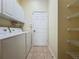 Functional laundry room with washer, dryer, storage cabinets, and shelving for organized convenience at 807 Wolf Creek St, Clermont, FL 34711
