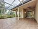 Screened patio with tile flooring, ceiling fans, and views of the yard and neighboring houses at 807 Wolf Creek St, Clermont, FL 34711
