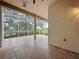 An open-air patio with tiled flooring and a screen enclosure overlooking the lush greenery of the yard at 807 Wolf Creek St, Clermont, FL 34711