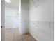 Clean and bright walk-in closet with wire shelving and neutral tile flooring for organized storage at 807 Wolf Creek St, Clermont, FL 34711
