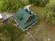 Aerial view of a large home with a green roof surrounded by mature trees and green grass at 8091 C 476B, Bushnell, FL 33513